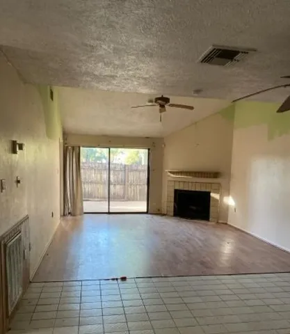 a view of a big room with chandelier fan and windows