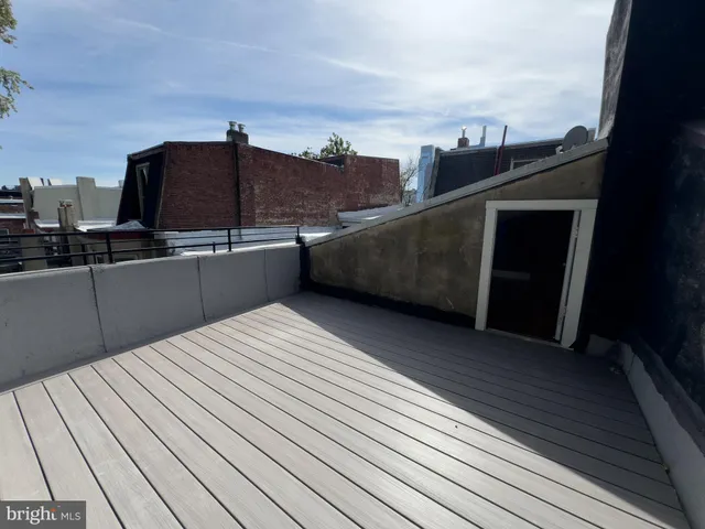 a view of wooden fence and trees in the background