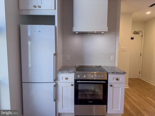 a kitchen with granite countertop a sink stove and cabinets