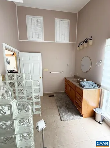 a bedroom with a bed lamp and a large window