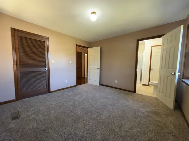 an empty room with closet and wooden door