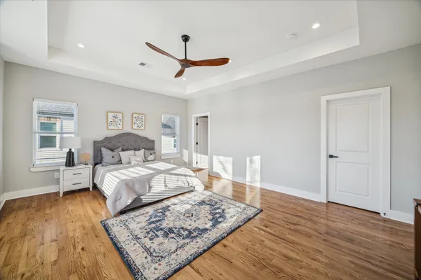 a living room with a bed furniture and wooden floor