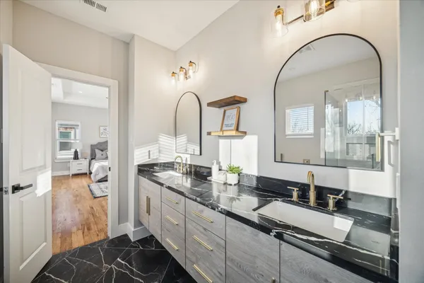 a large bathroom with a granite countertop sink a mirror and shower