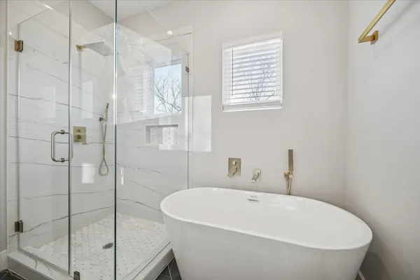 a white bath tub sitting next to a shower
