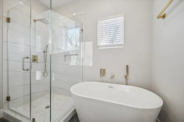 a large bathroom with a granite countertop tub sink a mirror a shower and vanity