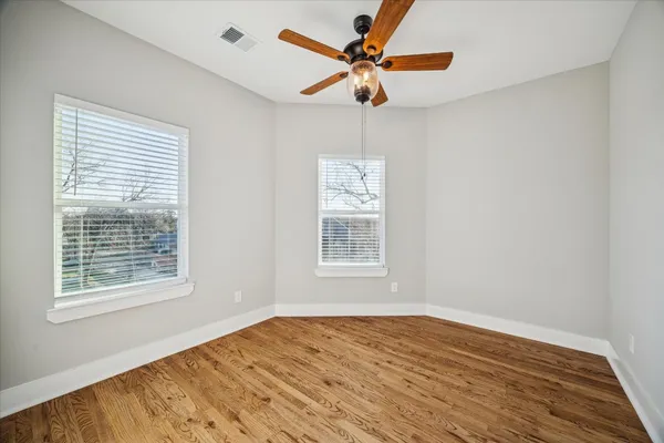 an empty room with window and ceiling fan