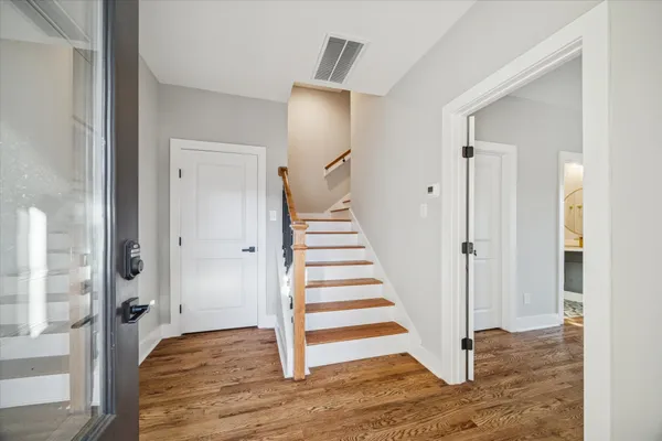 a view of a hallway with wooden floor and entryway
