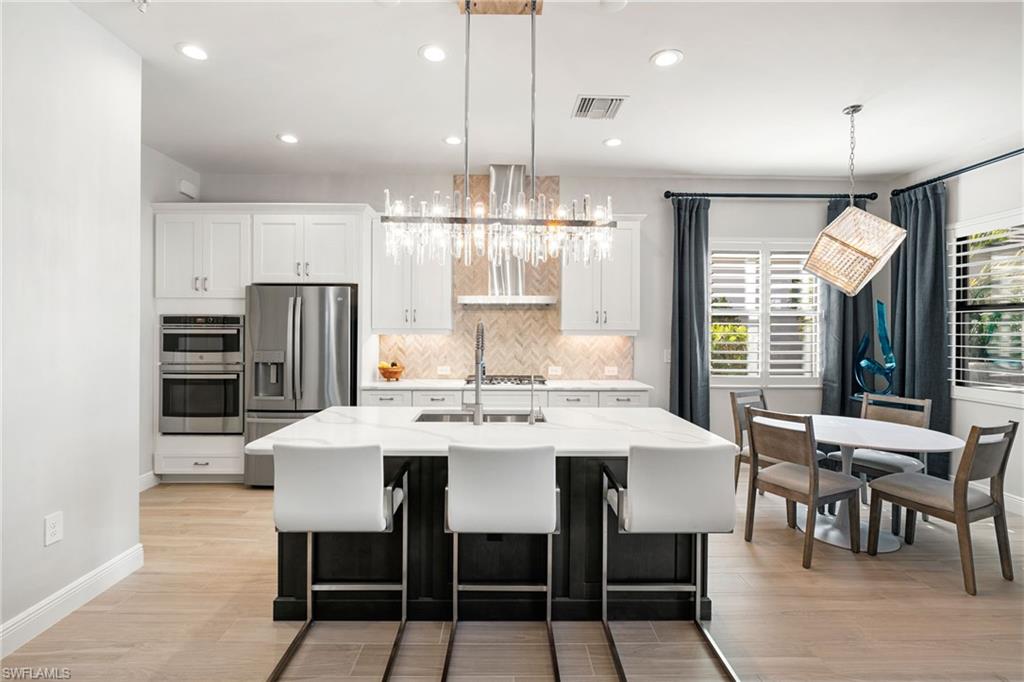 3967 Pegasus Way Naples, FL 34120 - Photo 10 of 50 a large kitchen with a table and chairs
