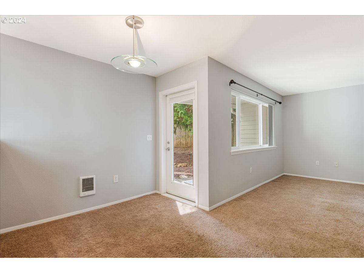 5225 Jean Road, Unit 313 Lake Oswego, OR 97035 - Photo 6 of 32 a view of an empty room with chandelier fan and windows