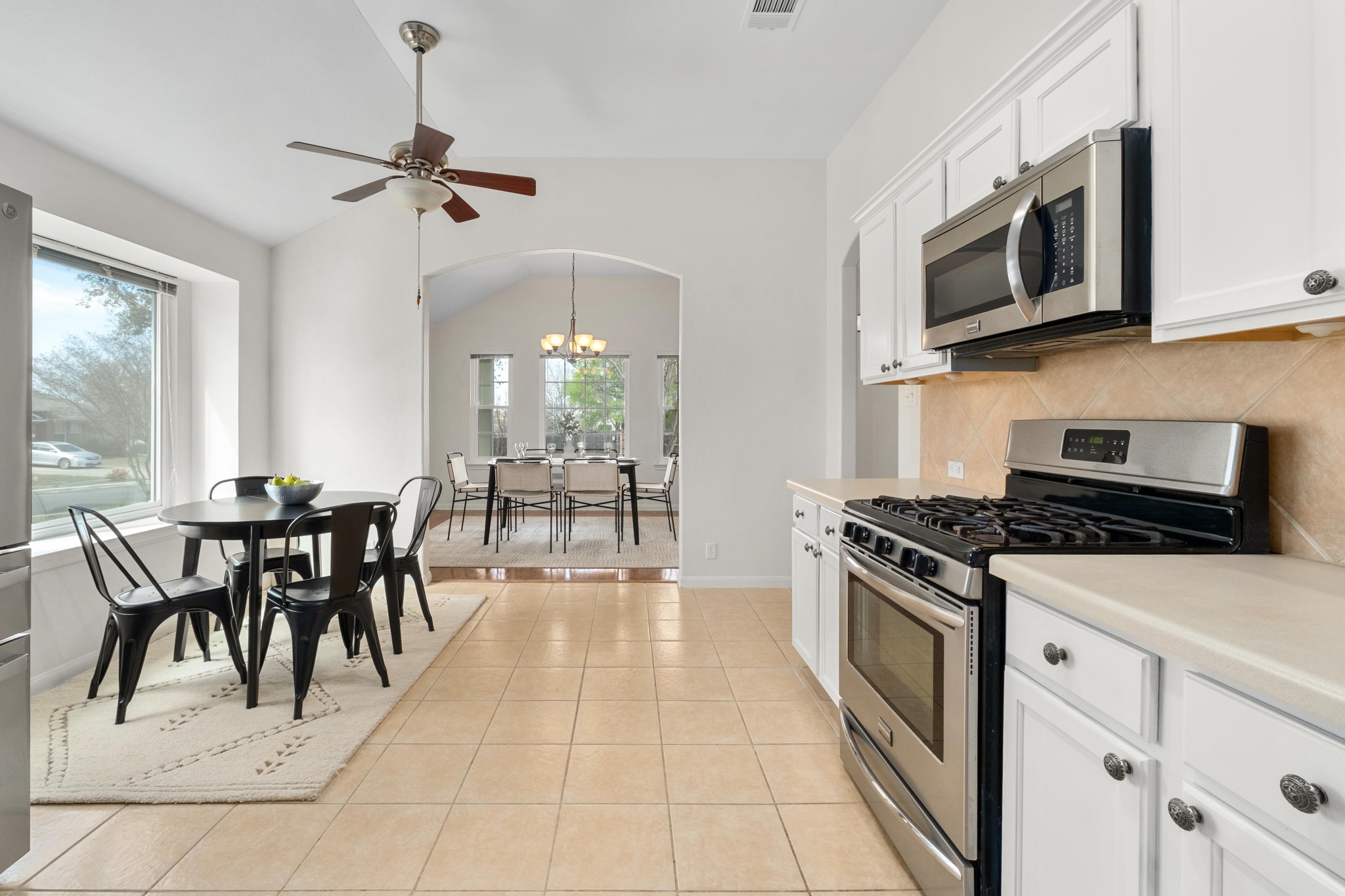 100 Pecanwood South Kyle, TX 78640 - Photo 15 of 35 Positioned between the dining room and living room, the kitchen serves as a central hub of the home with easy access to both spaces for serving meals or gathering with guests