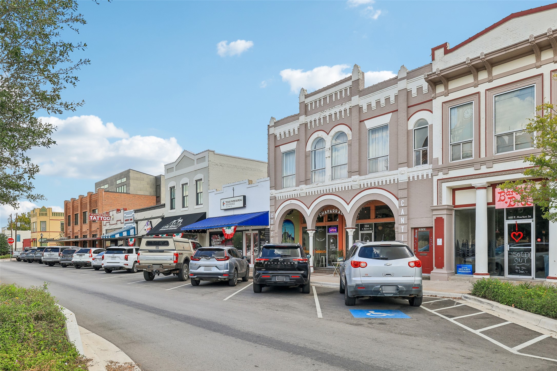 372 Old Lockhart Road Lockhart, TX 78644 - Photo 35 of 40 Historic brick storefronts align along a paved street with dedicated angled parking spaces.