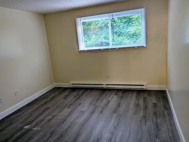 a view of a room with wooden floor and window
