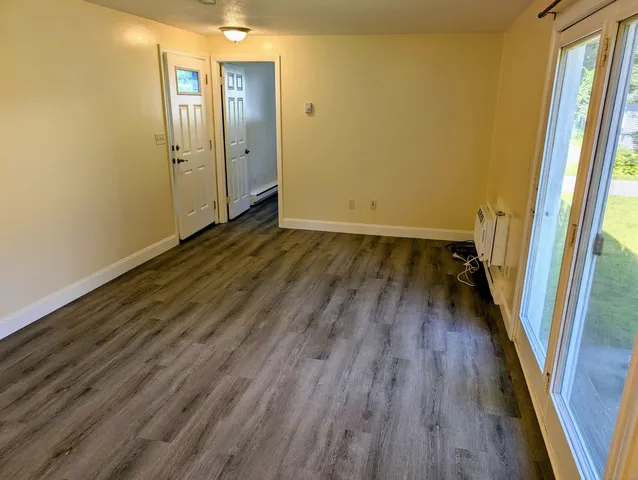 a view of front door with wooden floor and door