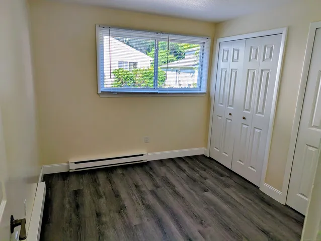 an empty room with wooden floor and a window