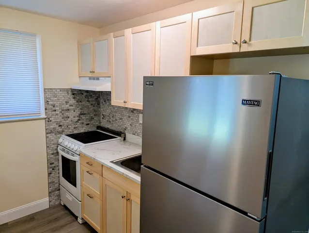 a kitchen with stainless steel appliances white cabinets and a refrigerator