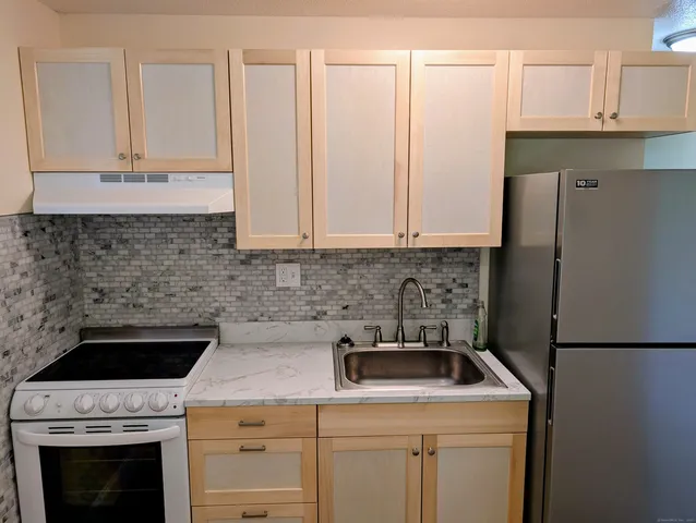 a kitchen with a sink stove and refrigerator