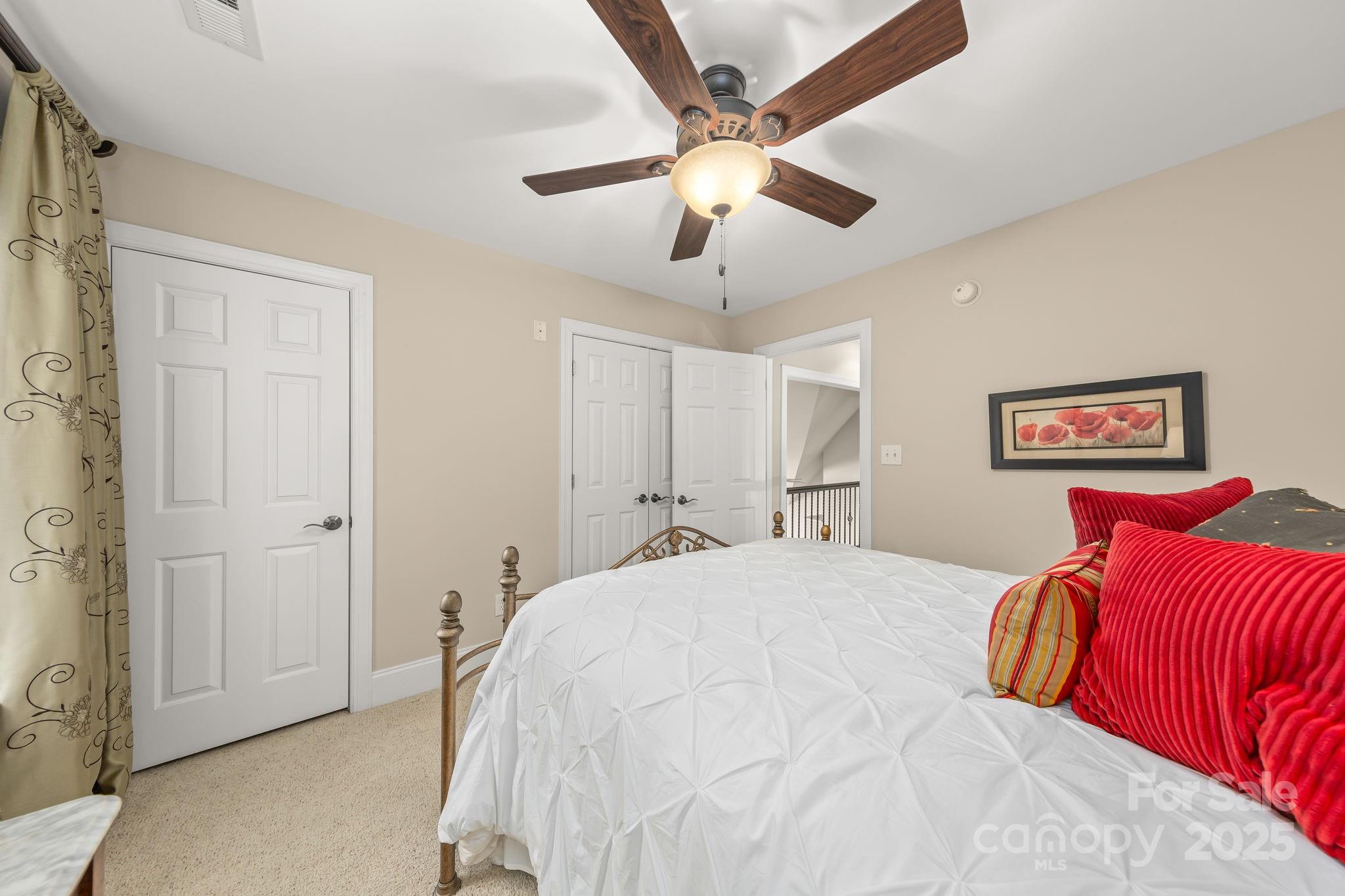 796 Lake Mist Drive Stanley, NC 28164 - Photo 24 of 43 a bedroom with a large bed and a chandelier