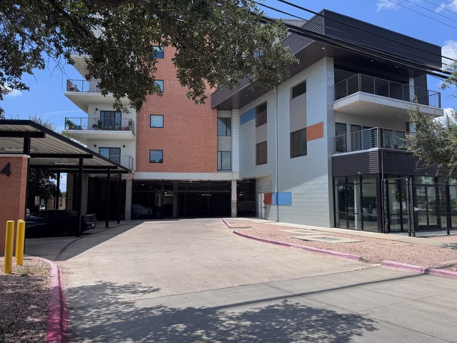 Modern multi-story building featuring private balconies and convenient covered parking.