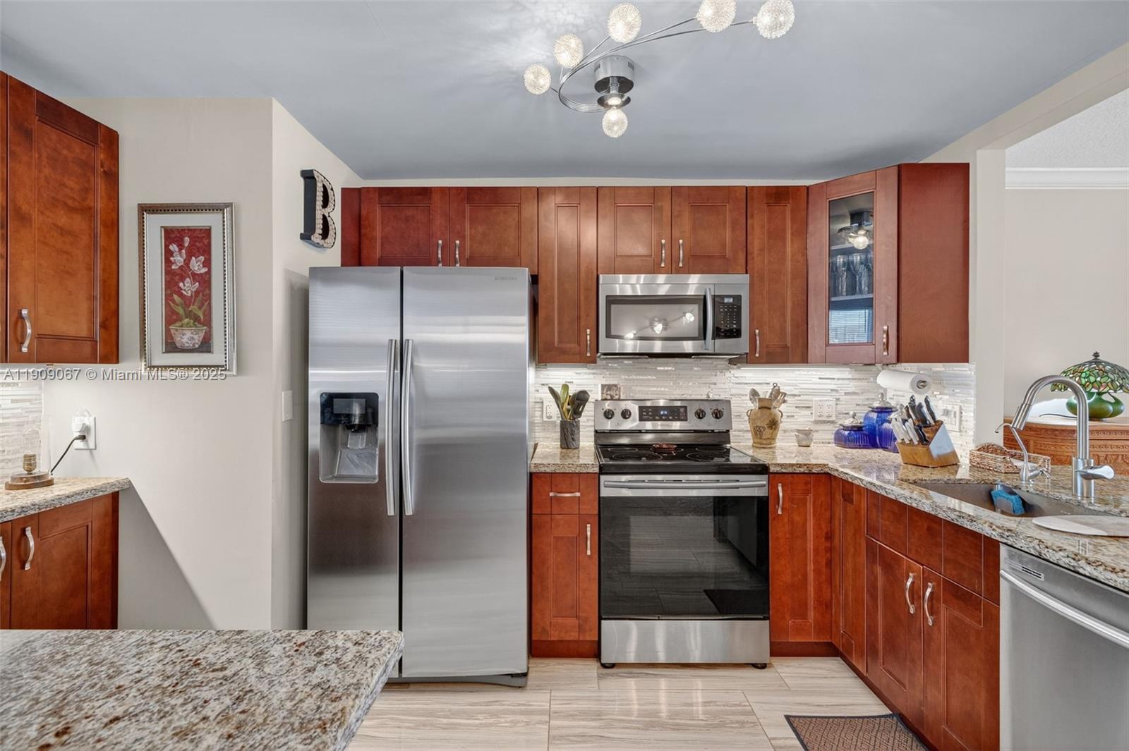 121 Golden Isles Drive, Unit 205 Hallandale Beach, FL 33009 - Photo 11 of 82 a kitchen with stainless steel appliances granite countertop a refrigerator stove and oven