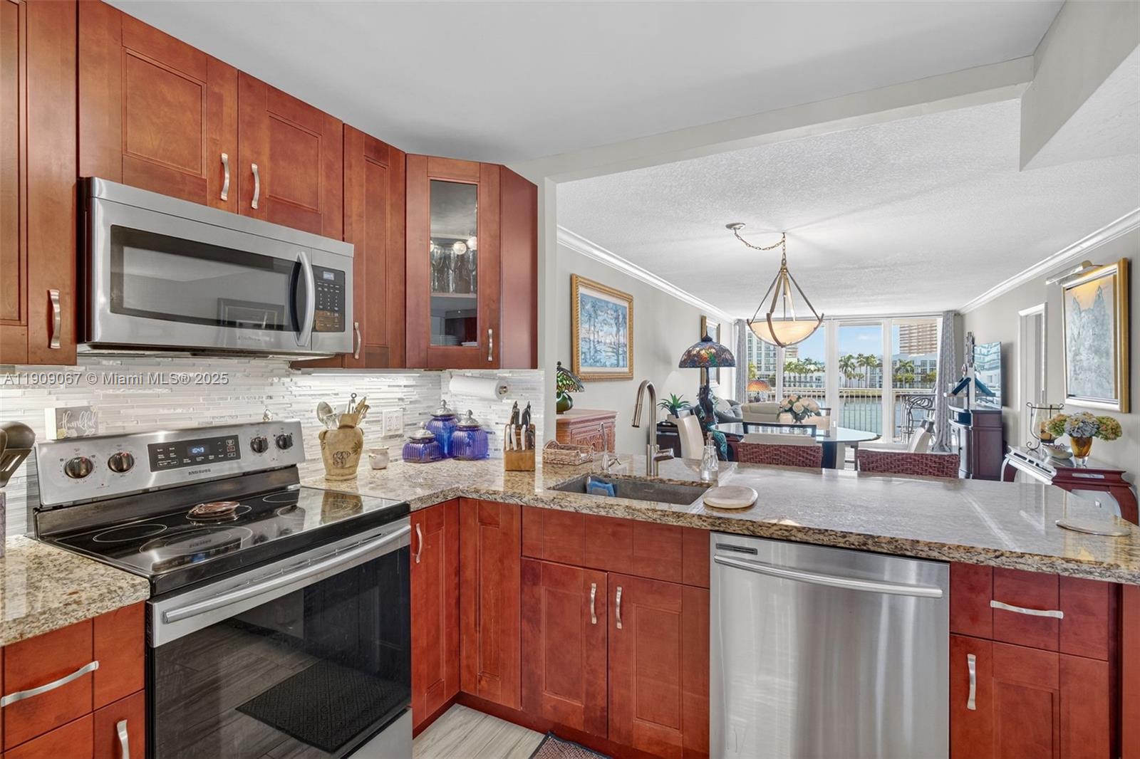 121 Golden Isles Drive, Unit 205 Hallandale Beach, FL 33009 - Photo 14 of 82 a kitchen with stainless steel appliances granite countertop a stove microwave and sink