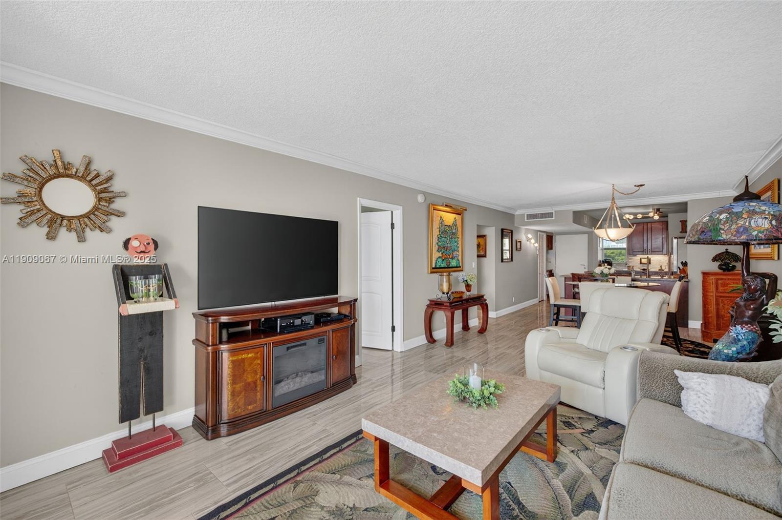 121 Golden Isles Drive, Unit 205 Hallandale Beach, FL 33009 - Photo 2 of 82 a living room with furniture and a flat screen tv
