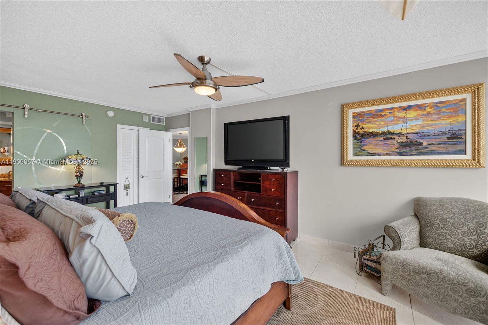 121 Golden Isles Drive, Unit 205 Hallandale Beach, FL 33009 - Photo 27 of 82 a bedroom with a bed and a flat screen tv