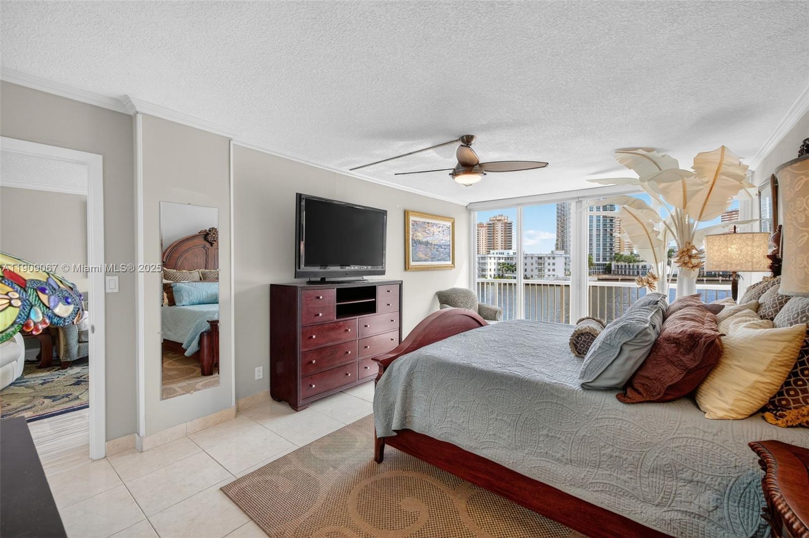 121 Golden Isles Drive, Unit 205 Hallandale Beach, FL 33009 - Photo 28 of 82 a bedroom with a bed and a television