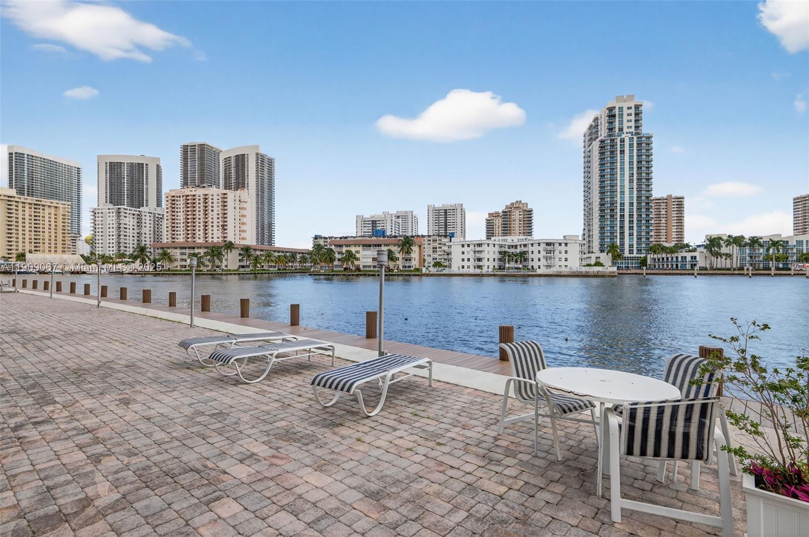 121 Golden Isles Drive, Unit 205 Hallandale Beach, FL 33009 - Photo 42 of 82 a view of a terrace with chairs and a table