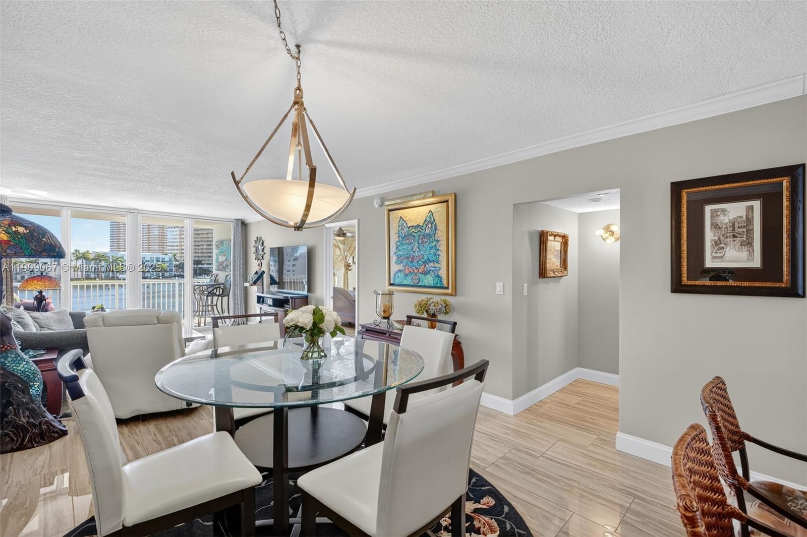 121 Golden Isles Drive, Unit 205 Hallandale Beach, FL 33009 - Photo 7 of 82 a view of a dining room with furniture wooden floor and a chandelier