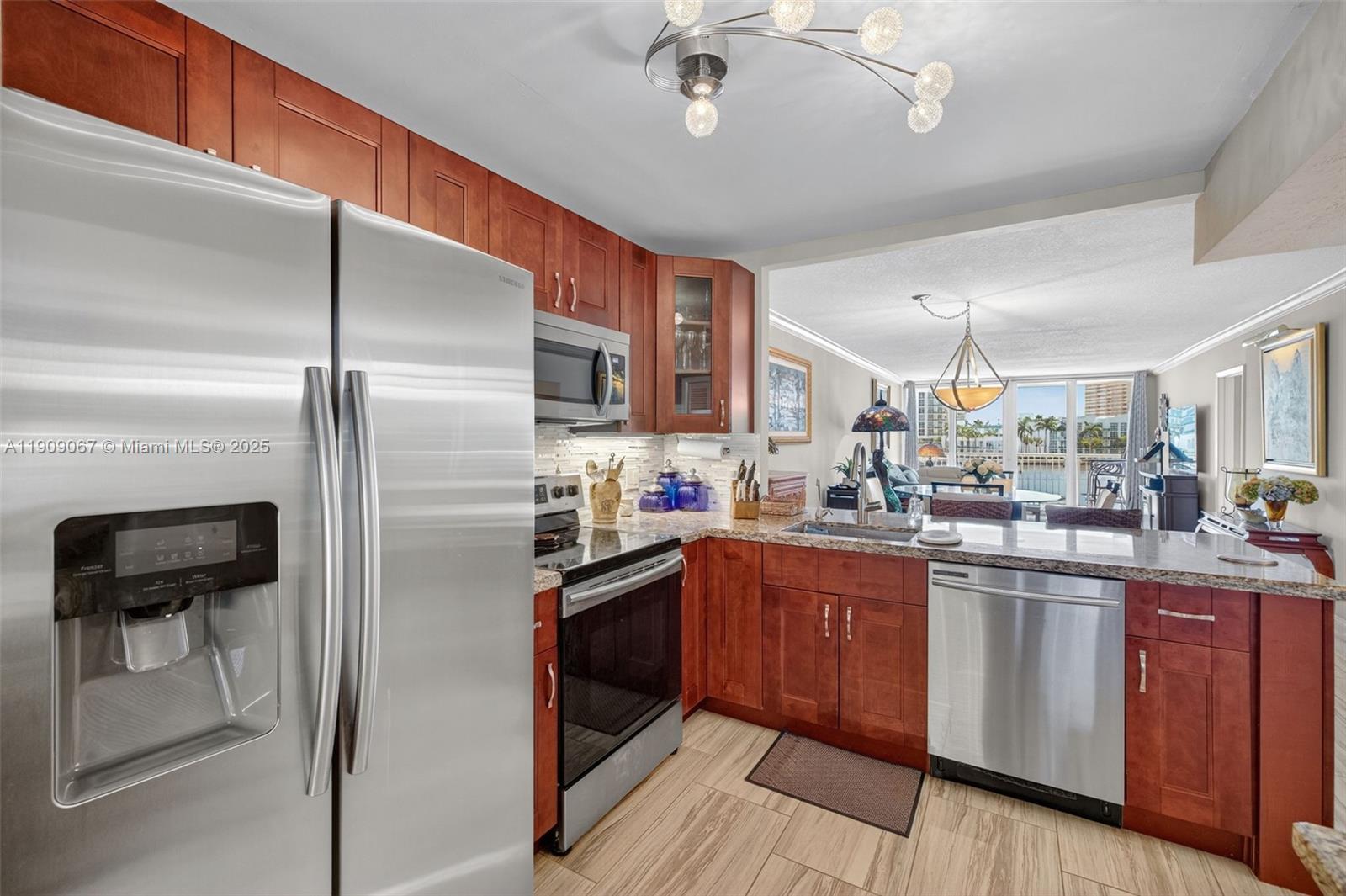 121 Golden Isles Drive, Unit 205 Hallandale Beach, FL 33009 - Photo 9 of 82 a kitchen with granite countertop a refrigerator a sink dishwasher a stove and a refrigerator