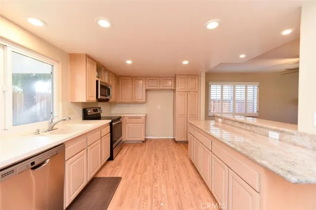 a large kitchen with stainless steel appliances lots of counter space and windows