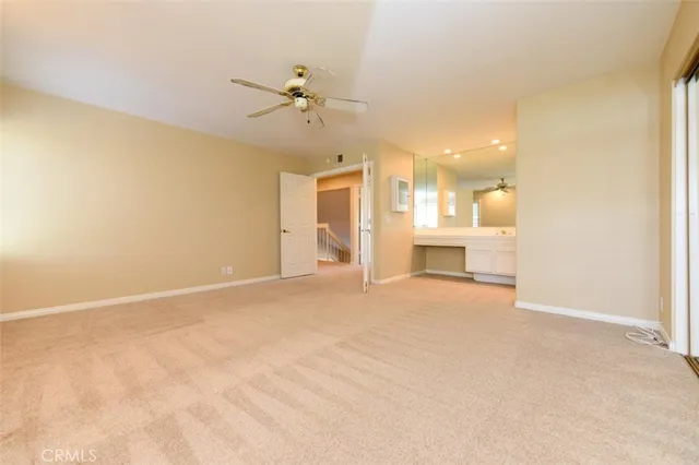 a view of a livingroom with a chandelier fan and kitchen view