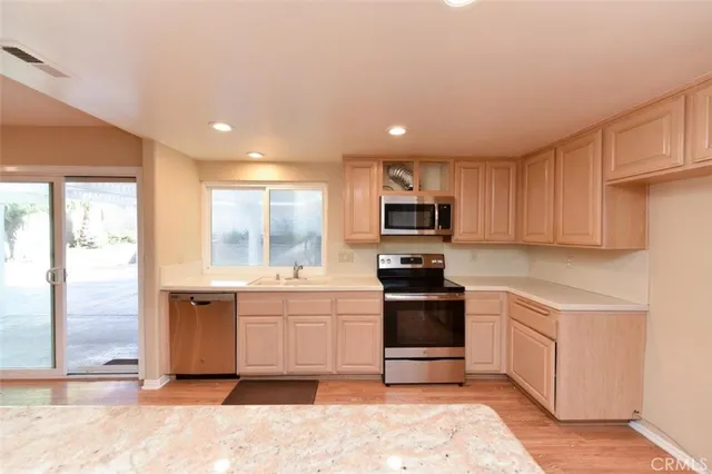 a kitchen with stainless steel appliances kitchen island granite countertop a sink and cabinets