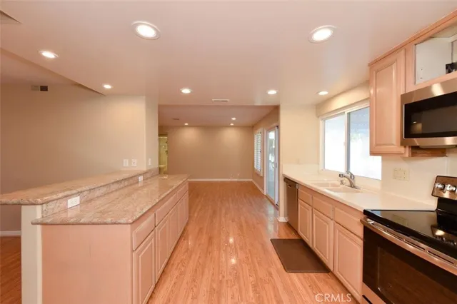a large kitchen with kitchen island a sink stainless steel appliances and cabinets