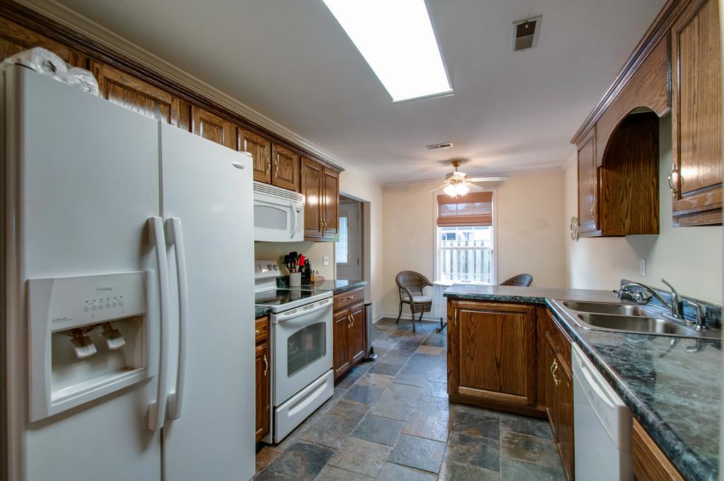1101 General George Patton Road, Unit 1101 Nashville, TN 37221 - Photo 11 of 30 a kitchen with stainless steel appliances granite countertop a sink stove and refrigerator
