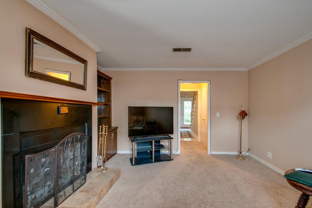 1101 General George Patton Road, Unit 1101 Nashville, TN 37221 - Photo 17 of 30 a living room with fireplace and a flat screen tv
