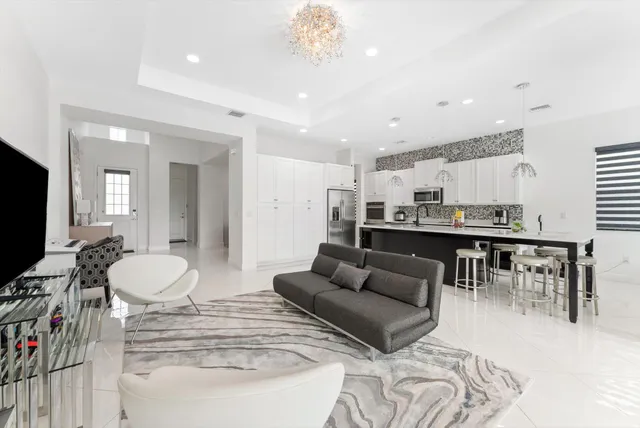 a kitchen with stainless steel appliances granite countertop a stove top oven a sink a dining table and chairs