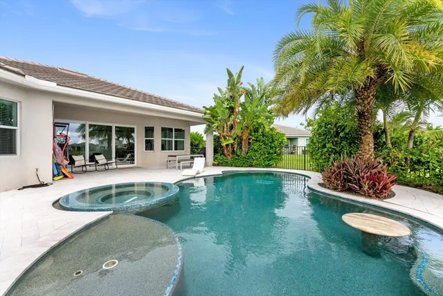 a view of swimming pool with lawn chairs and plants