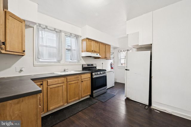 a kitchen with stainless steel appliances granite countertop a refrigerator a sink dishwasher a stove with wooden cabinets