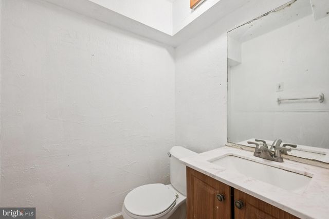 a bathroom with a granite countertop sink and a toilet