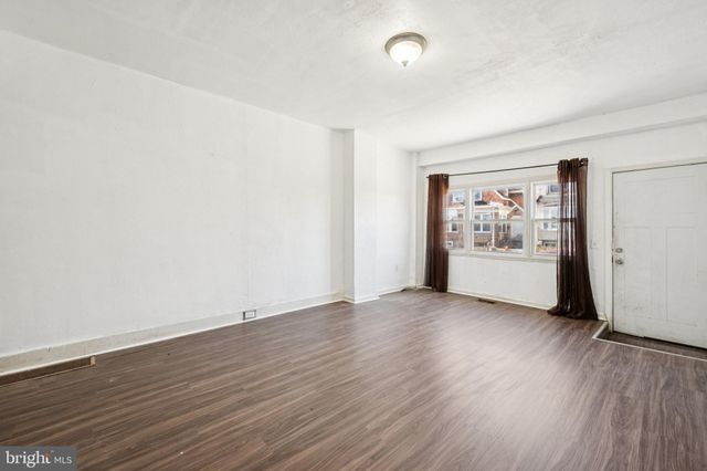 an empty room with wooden floor and white walls