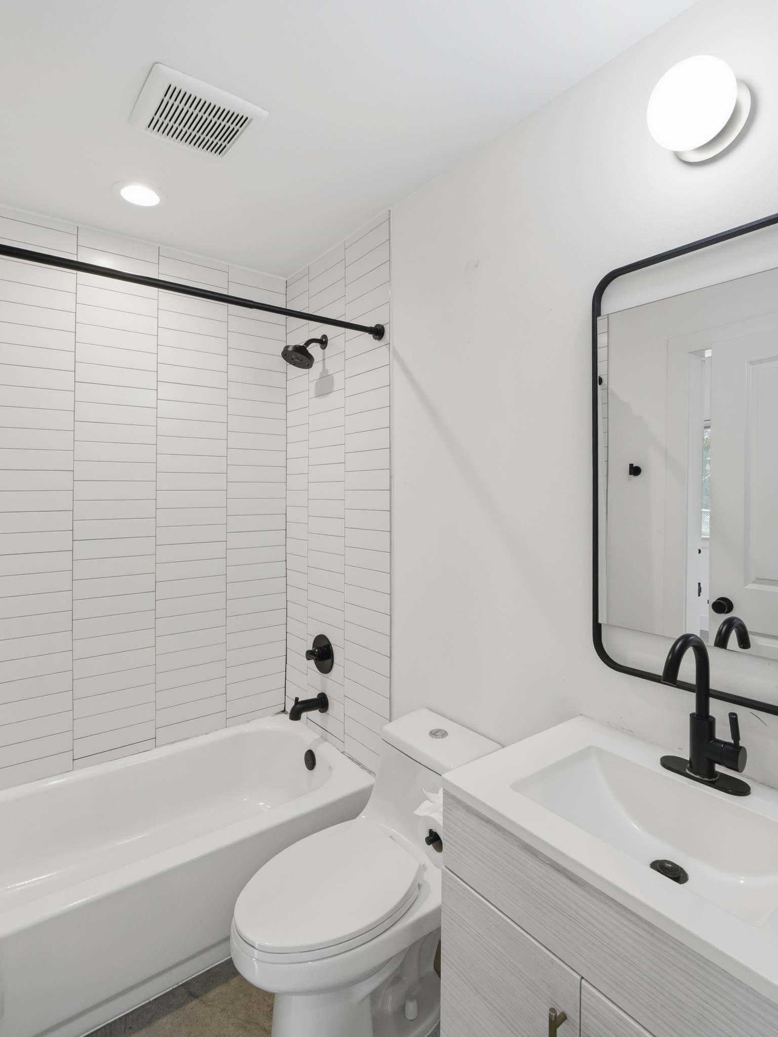 5005 Lott Avenue, Unit 2 Austin, TX 78721 - Photo 9 of 25 A well-lit, contemporary bathroom presents clean lines and sleek black fixtures.