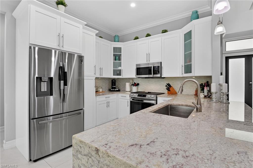 2642 10th Avenue Northeast Naples, FL 34120 - Photo 10 of 38 a kitchen with stainless steel appliances a refrigerator stove microwave and sink