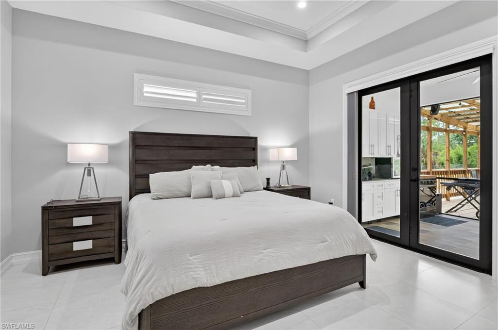 2642 10th Avenue Northeast Naples, FL 34120 - Photo 16 of 38 a bedroom with a bed and a night stand