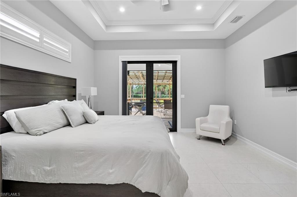 2642 10th Avenue Northeast Naples, FL 34120 - Photo 17 of 38 a bedroom with a bed and a flat screen tv