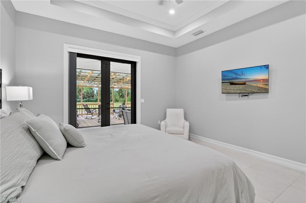 2642 10th Avenue Northeast Naples, FL 34120 - Photo 18 of 38 a bedroom with a bed and a large window