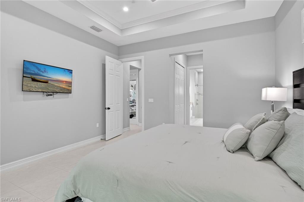 2642 10th Avenue Northeast Naples, FL 34120 - Photo 19 of 38 a bedroom with a bed and a painting on the wall