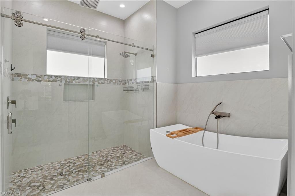 2642 10th Avenue Northeast Naples, FL 34120 - Photo 22 of 38 a bathroom with a tub and a shower