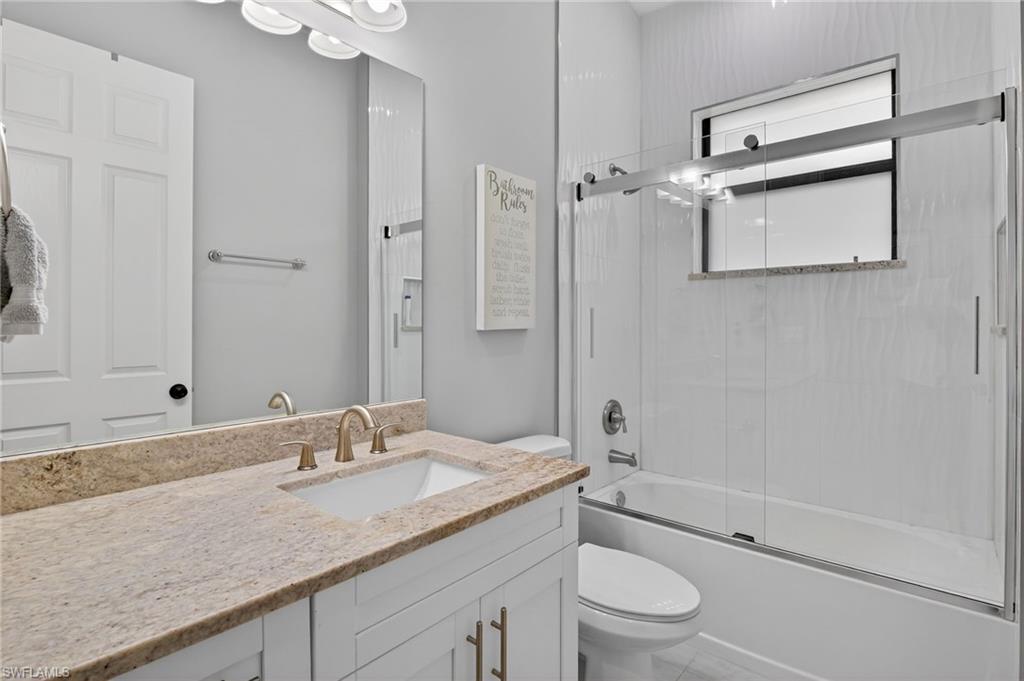 2642 10th Avenue Northeast Naples, FL 34120 - Photo 24 of 38 a bathroom with a granite countertop sink toilet and shower