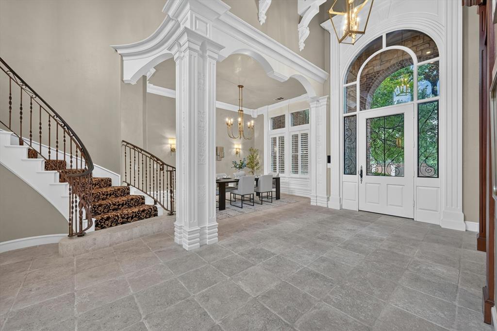 6416 Riverside Drive Plano, TX 75024 - Photo 2 of 35 Grand entryway featuring large format tile flooring, a sweeping staircase with an ornate wrought iron railing, and a decorative archway